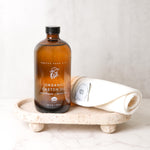 Bottle of organic castor oil on a stone tray with a white background