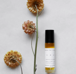 Era natural perfume roll-on bottle displayed with dried flowers on a clean neutral background