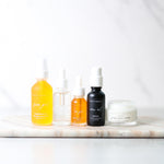 Set of skincare products on a marble surface with a white background