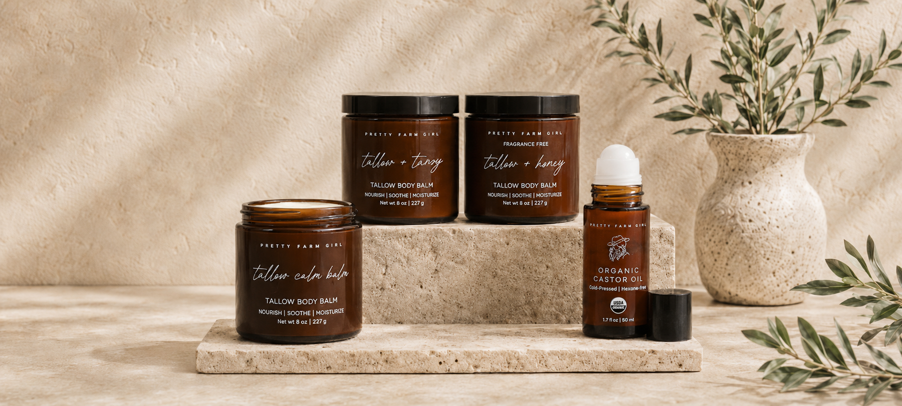 Pretty Farm Girl new arrivals featuring Tallow Body Balms and Organic Castor Oil Roller displayed on a neutral stone shelf.