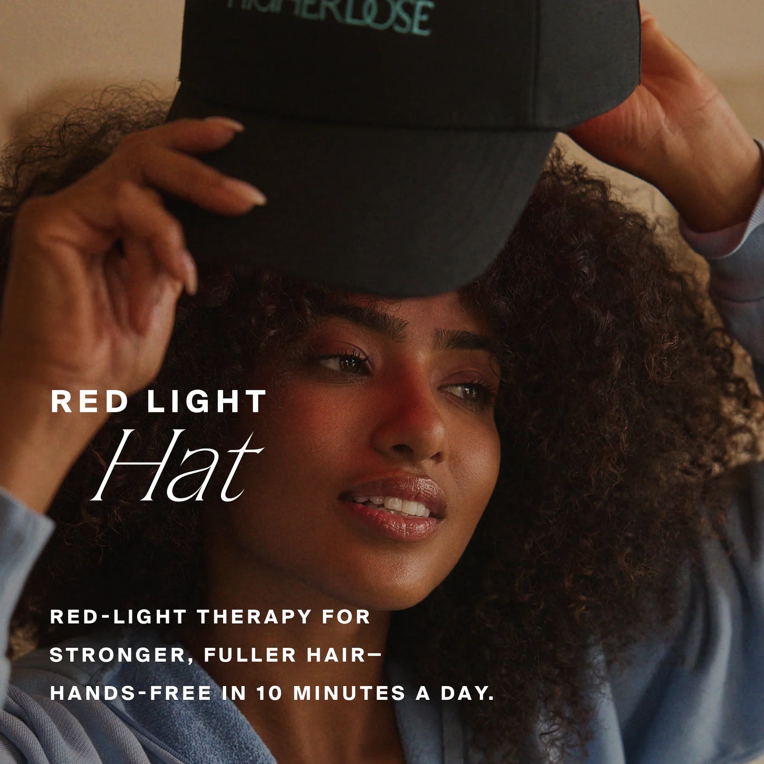 Person wearing a black cap with text about red-light therapy for hair growth.