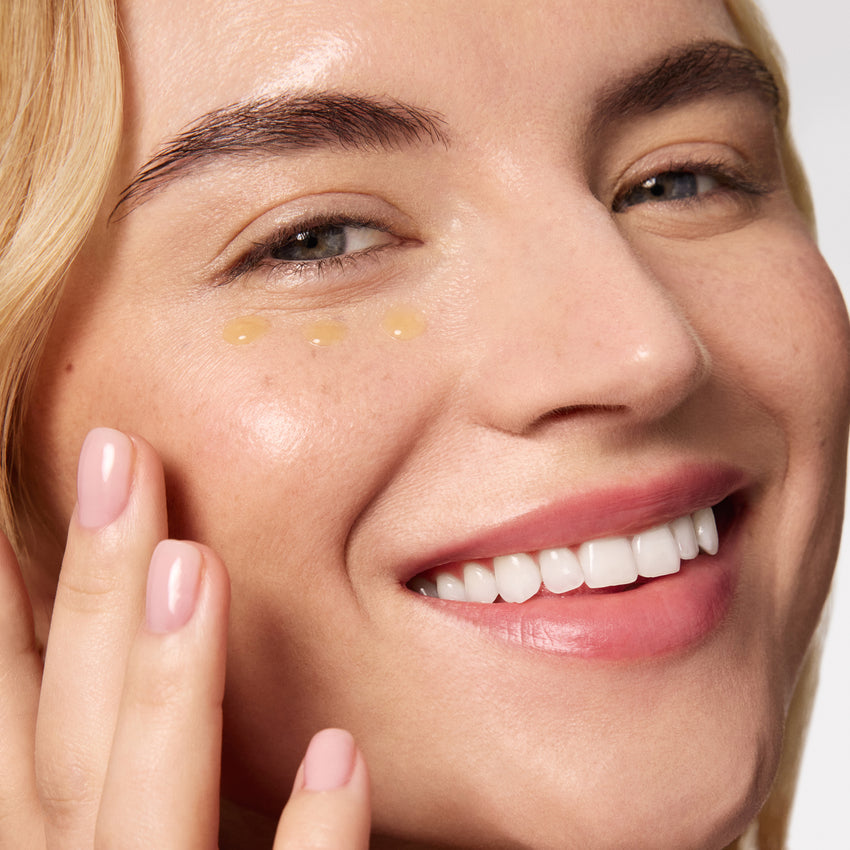 Close-up of a woman's face with skincare product application on her cheek