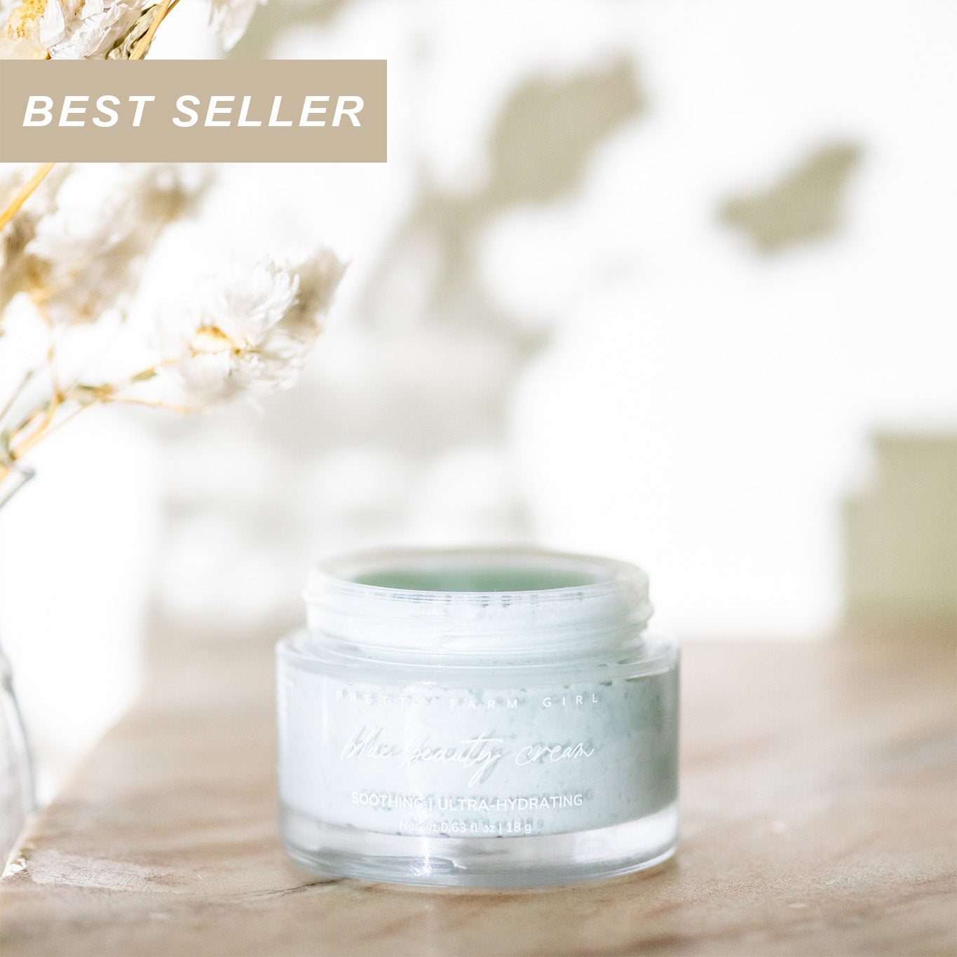 Blue Beauty Cream jar labeled 'Best Seller' on a blurred natural background