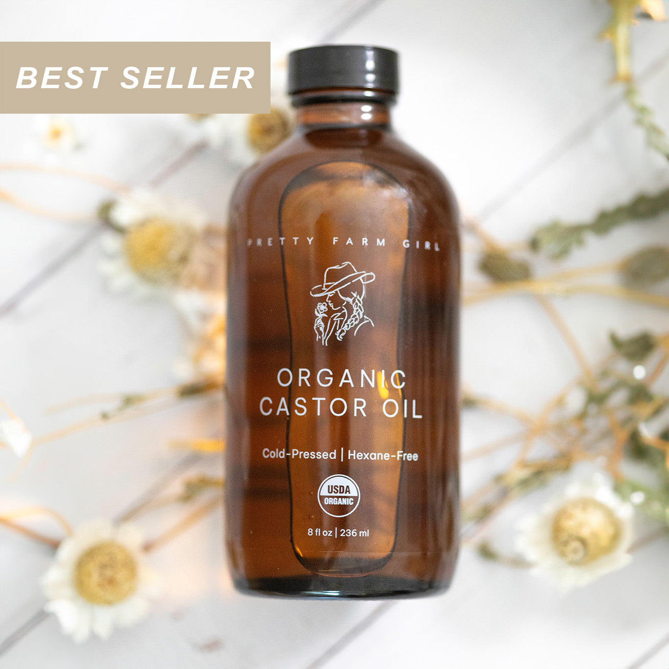 Brown glass bottle of organic castor oil with a best seller label on a light background