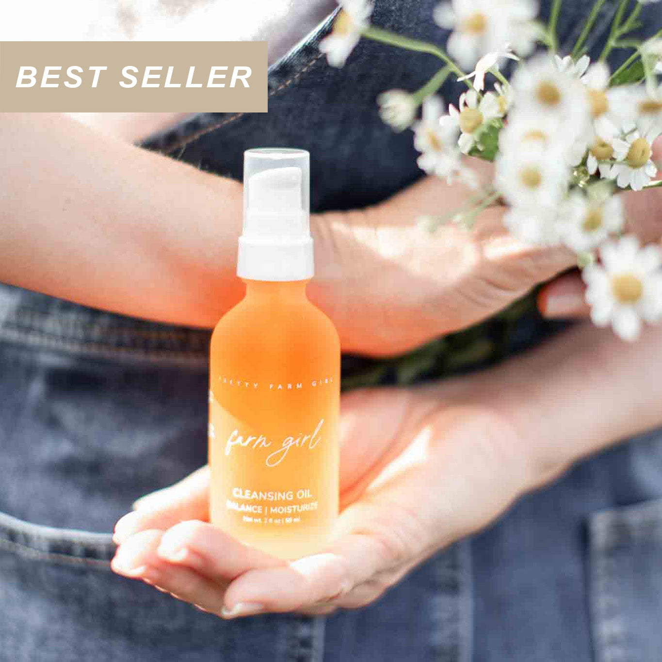 Person holding an orange bottle labeled 'farm girl cleansing oil' with flowers in the background and a best seller label in the corner