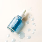 Blue skincare serum bottle with dropper on a light background