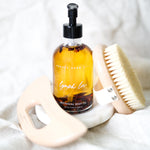 Bottle of 'Lymph Love' botanical body oil with a brush on a white background