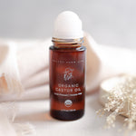 Pretty Farm Girl Organic Castor Oil roller bottle 1.7 fl oz with cap on neutral background with dried flowers