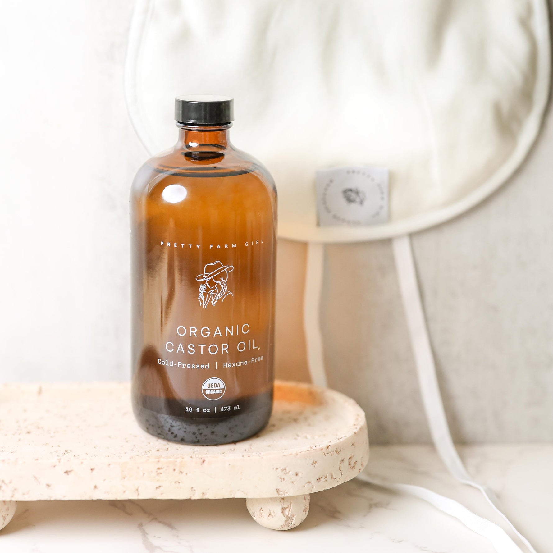 Bottle of organic castor oil on a stone surface with a neutral background