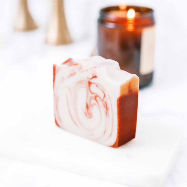 Citrus Cedarwood Soap Bar on a soft neutral background with a candle in the background