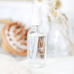 Clear facial toner bottle with text on a blurred natural background