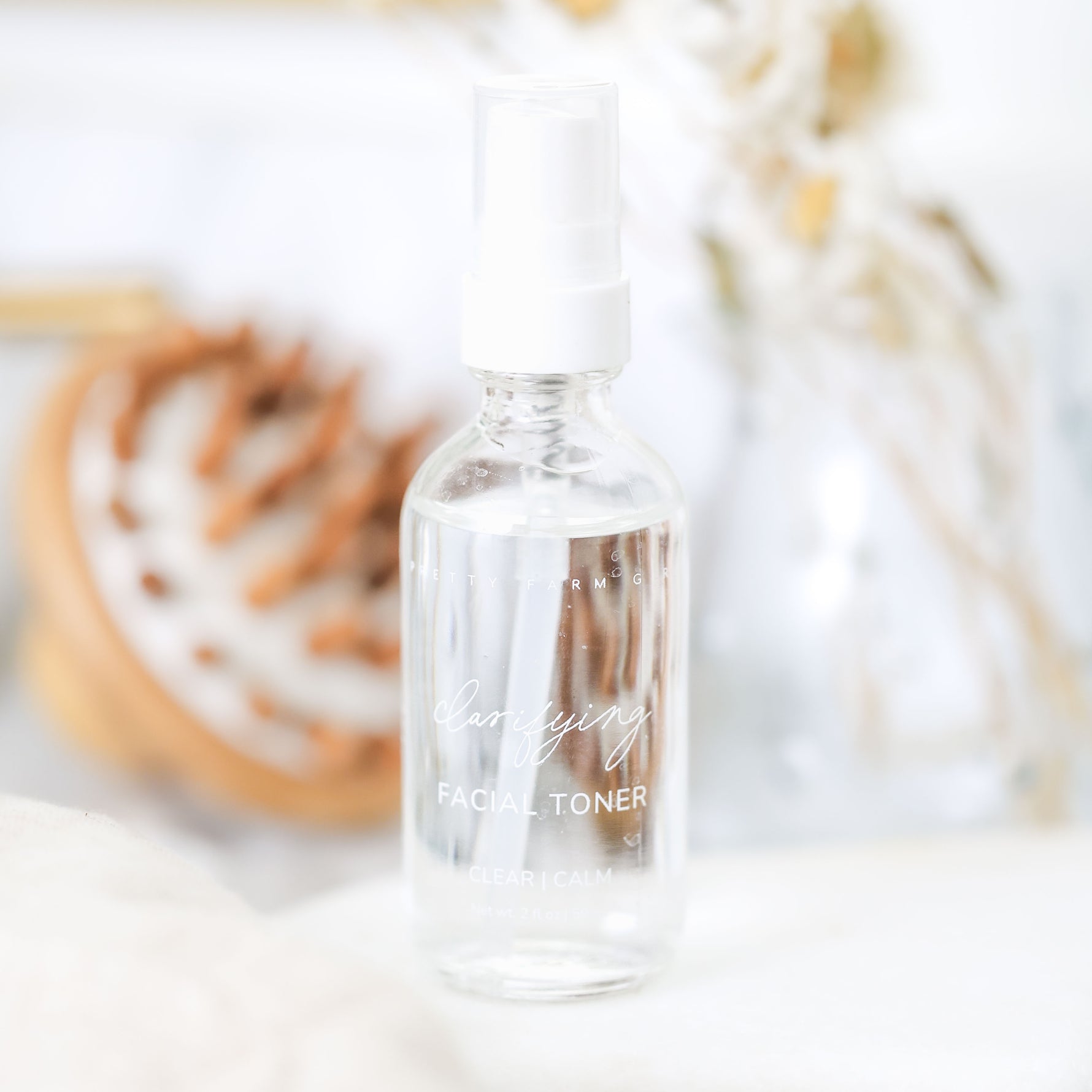 Clear facial toner bottle with text on a blurred natural background