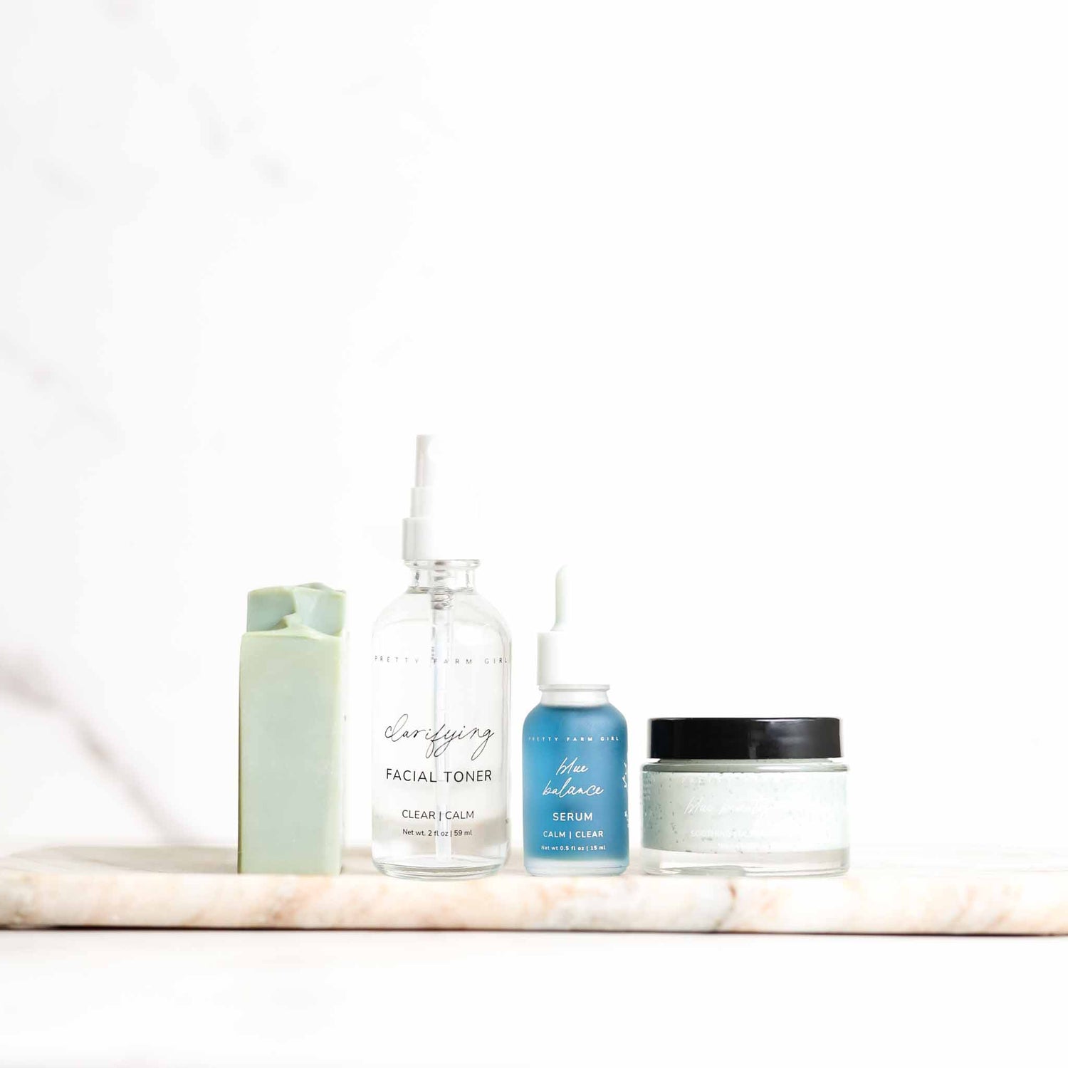 Set of skincare products on a marble shelf with a white background