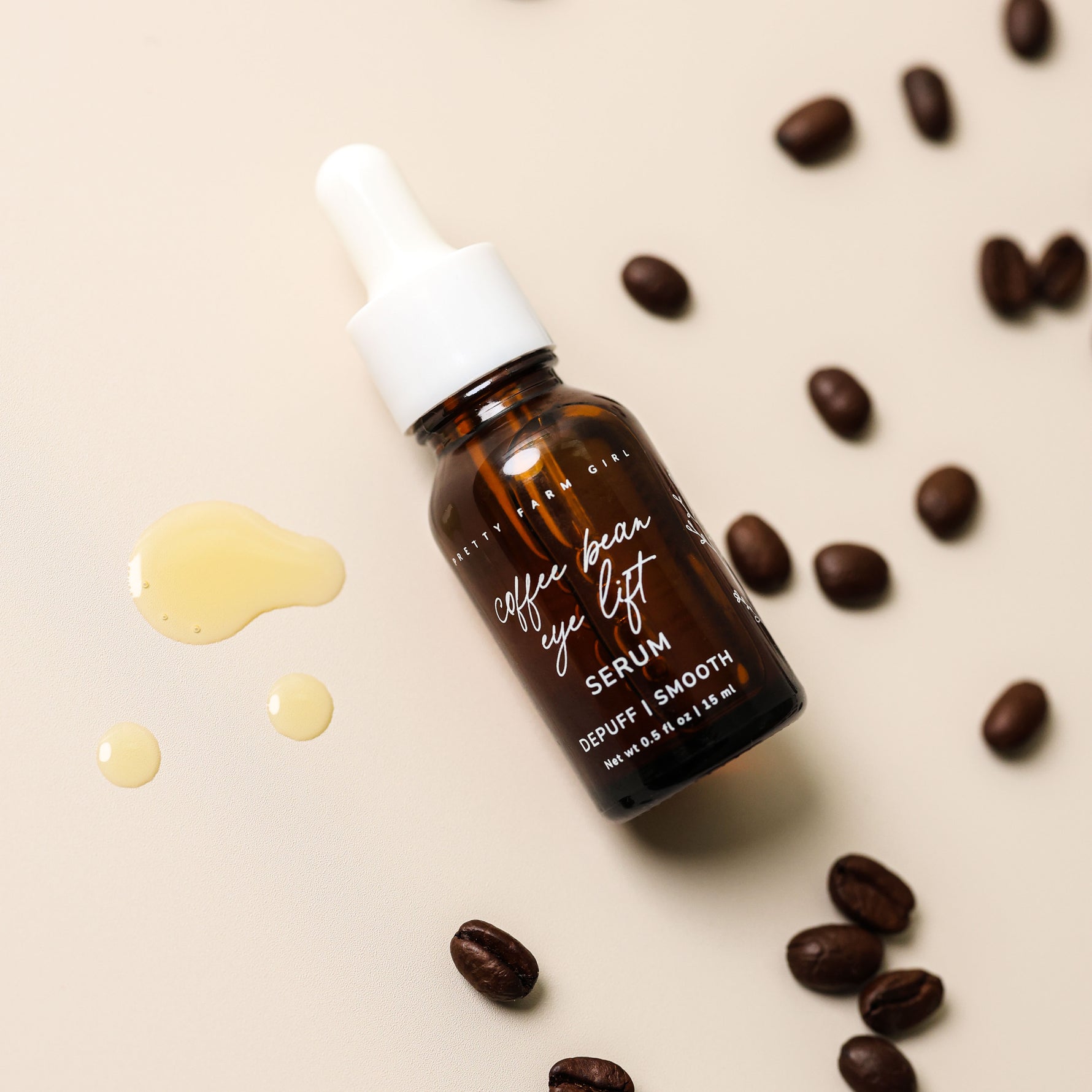 Pretty Farm Girl Coffee Bean Eye Lift Serum bottle surrounded by coffee beans and serum drops