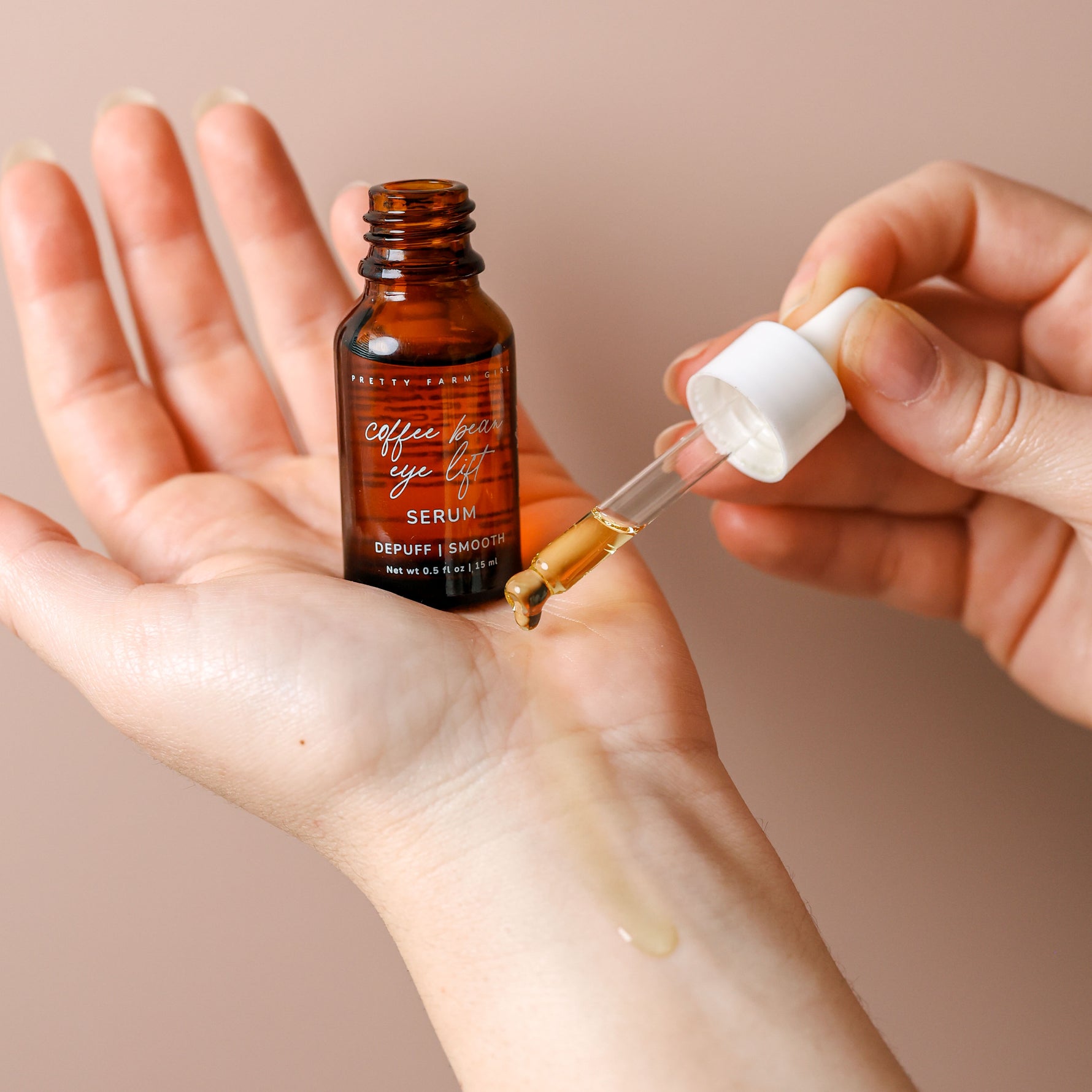 Coffee Bean Eye Lift Serum applied to the wrist with glass dropper to see the texture