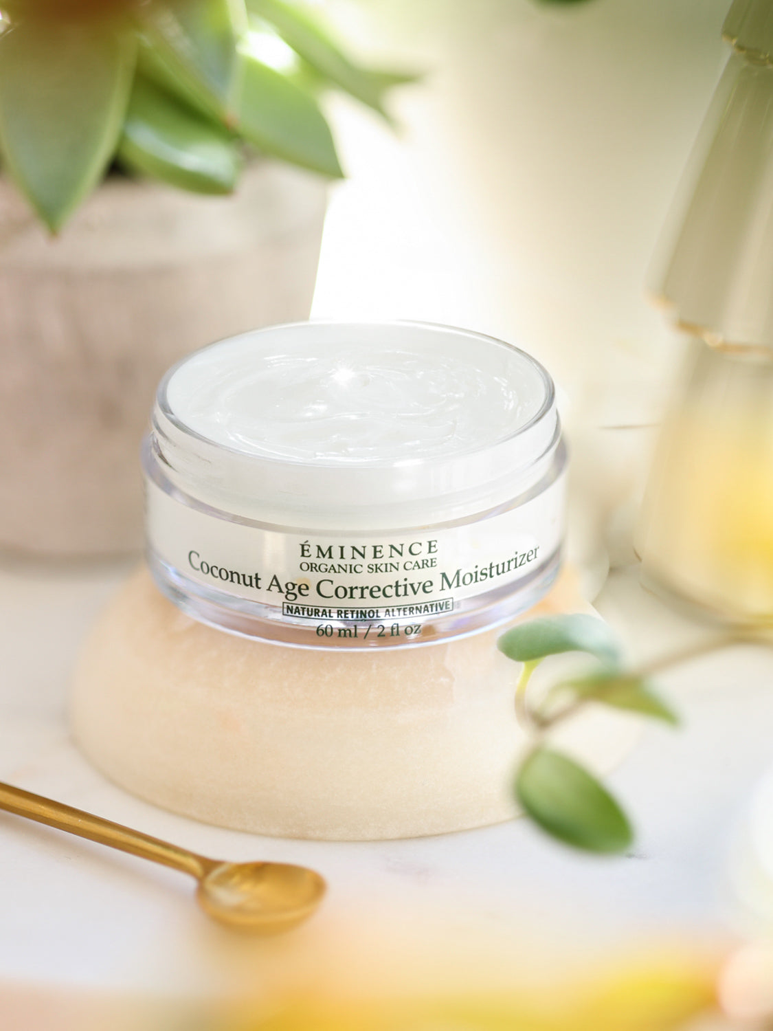 Coconut Age Corrective Moisturizer jar by Eminence with a blurred natural background