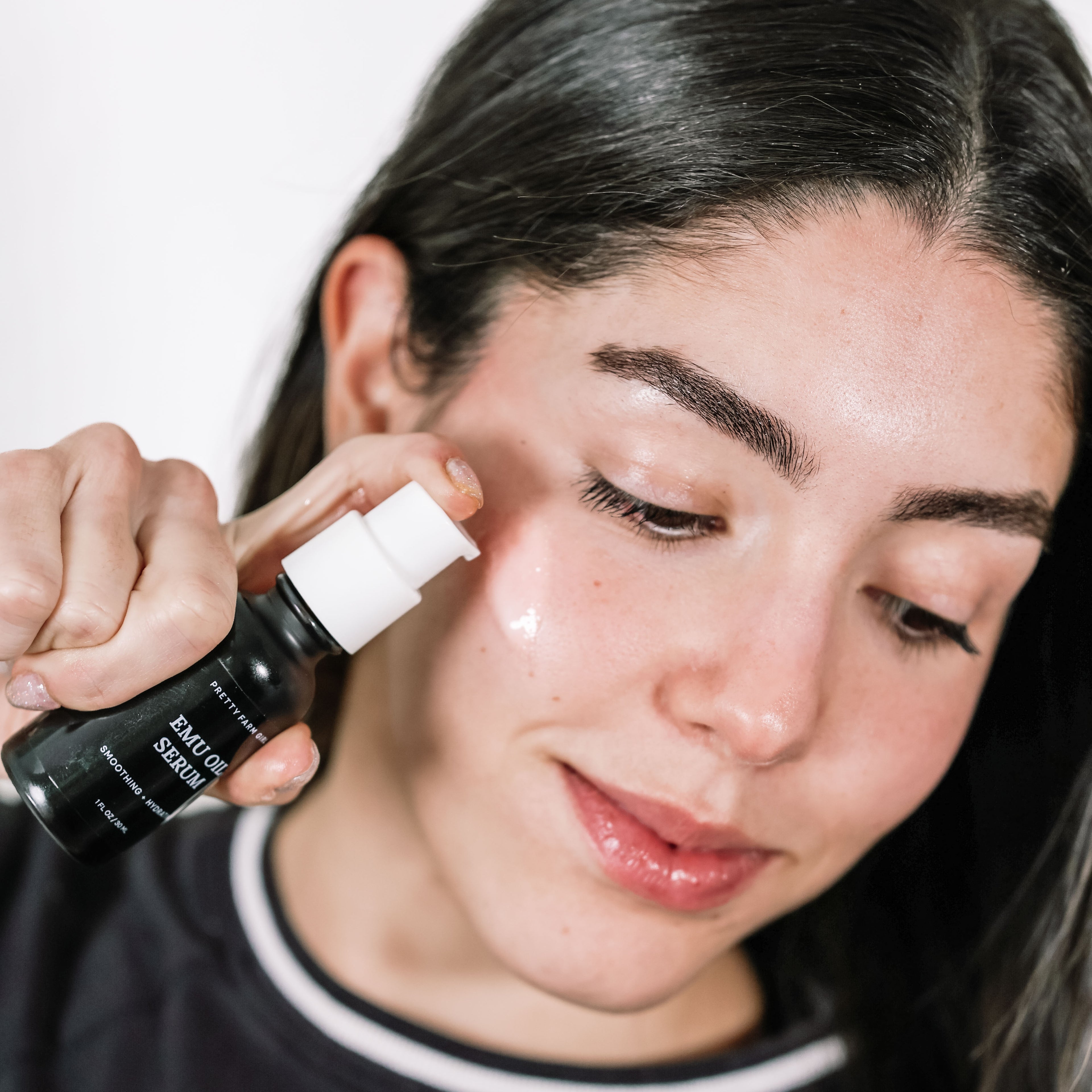 Person applying a Emu Oil Serum to their face