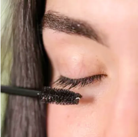 Person applying Pretty Farm Girl's eyelash growth serum to their eyelashes with a brush