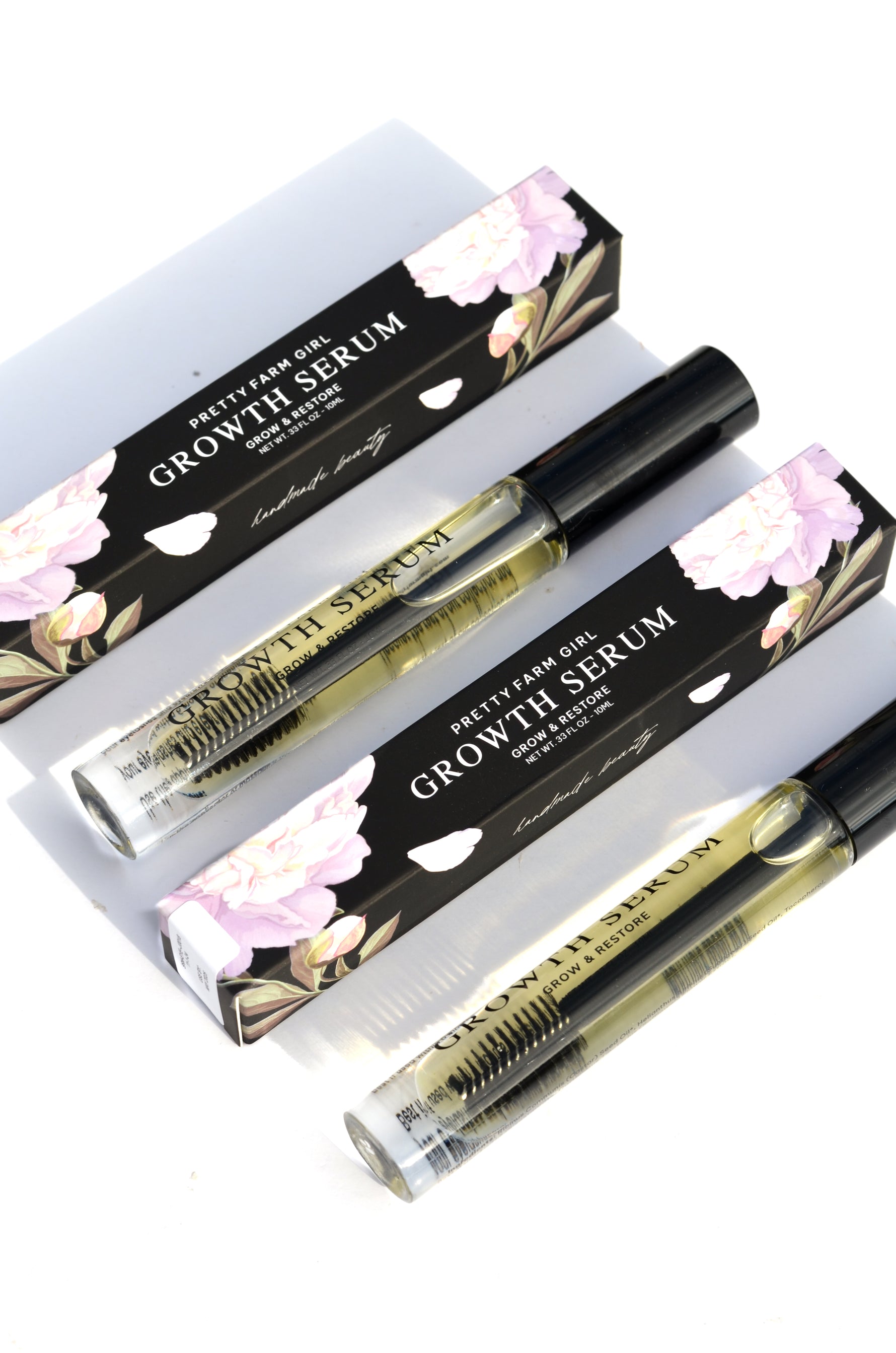 Eyelash + Eyebrow Growth Serum tubes with product packaging on a clean white background