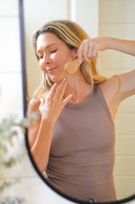 Face dry brush being used in mirror