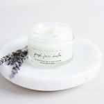 Pretty Farm Girl Fresh Face Cream jar on a white plate with lavender botanical accents.