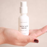 Pretty Farm Girl Lactic Acid Serum bottle displayed in a hand on a soft neutral background
