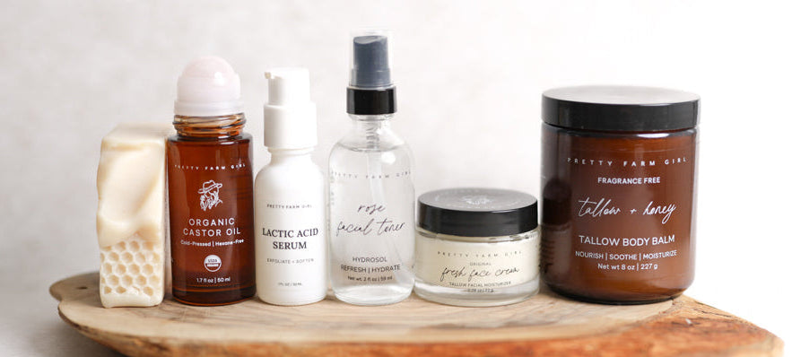 Collection of skincare and body care products on a wooden tray with a neutral background