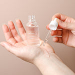 Hyaluronic Plumping Serum with Vitamin B5 and Snow Mushroom applied to the hand with glass dropper