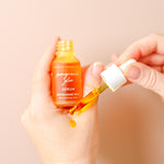 Pomegranate Glow Natural Skin Protecting Serum dropper applying golden serum texture onto the skin