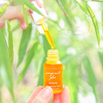 Pomegranate Glow Natural Skin Protecting Serum bottle in natural light with natural background