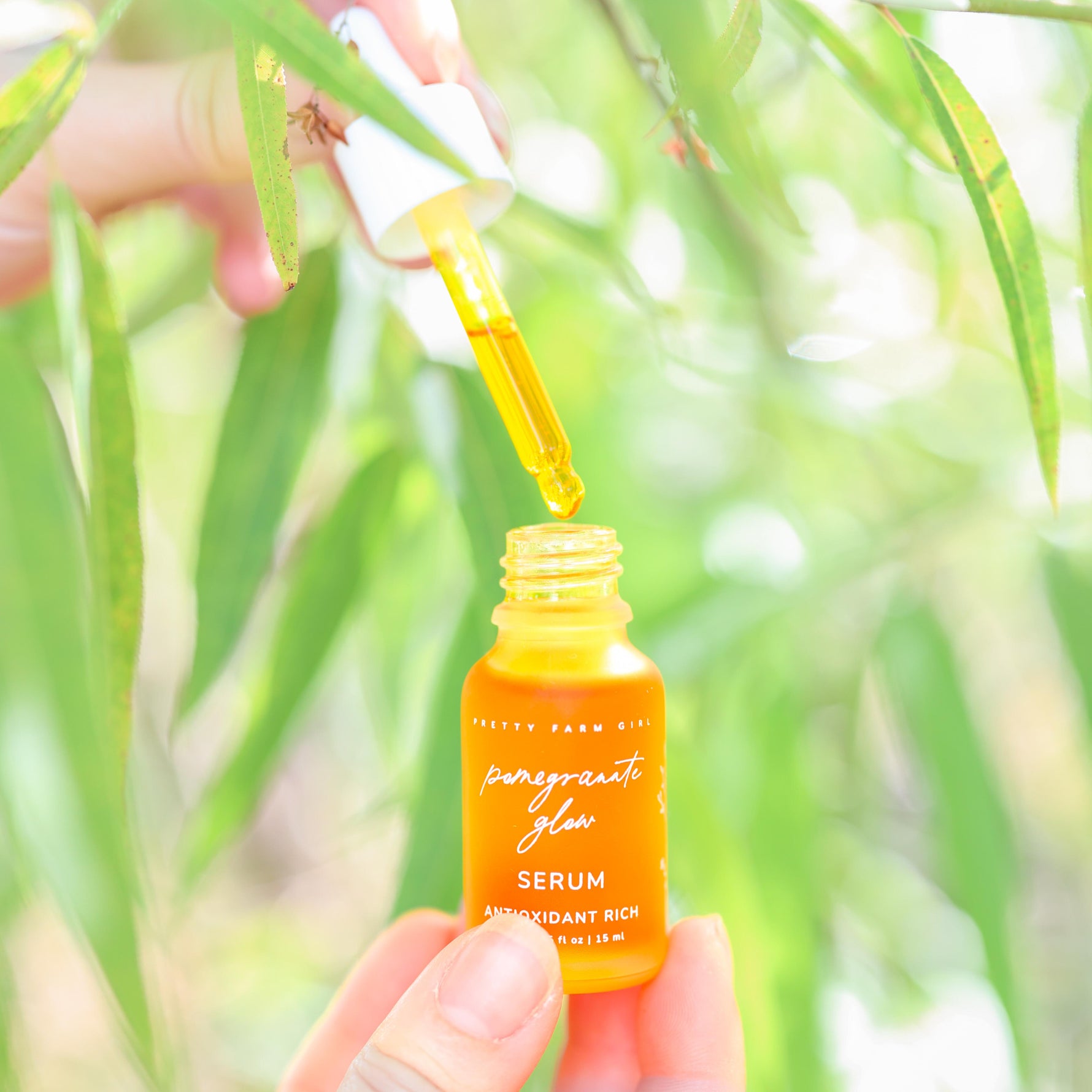 Pomegranate Glow Natural Skin Protecting Serum bottle in natural light with natural background