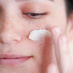 Woman applying Pretty Farm Girl "Tallow Calm Balm" to her cheek.