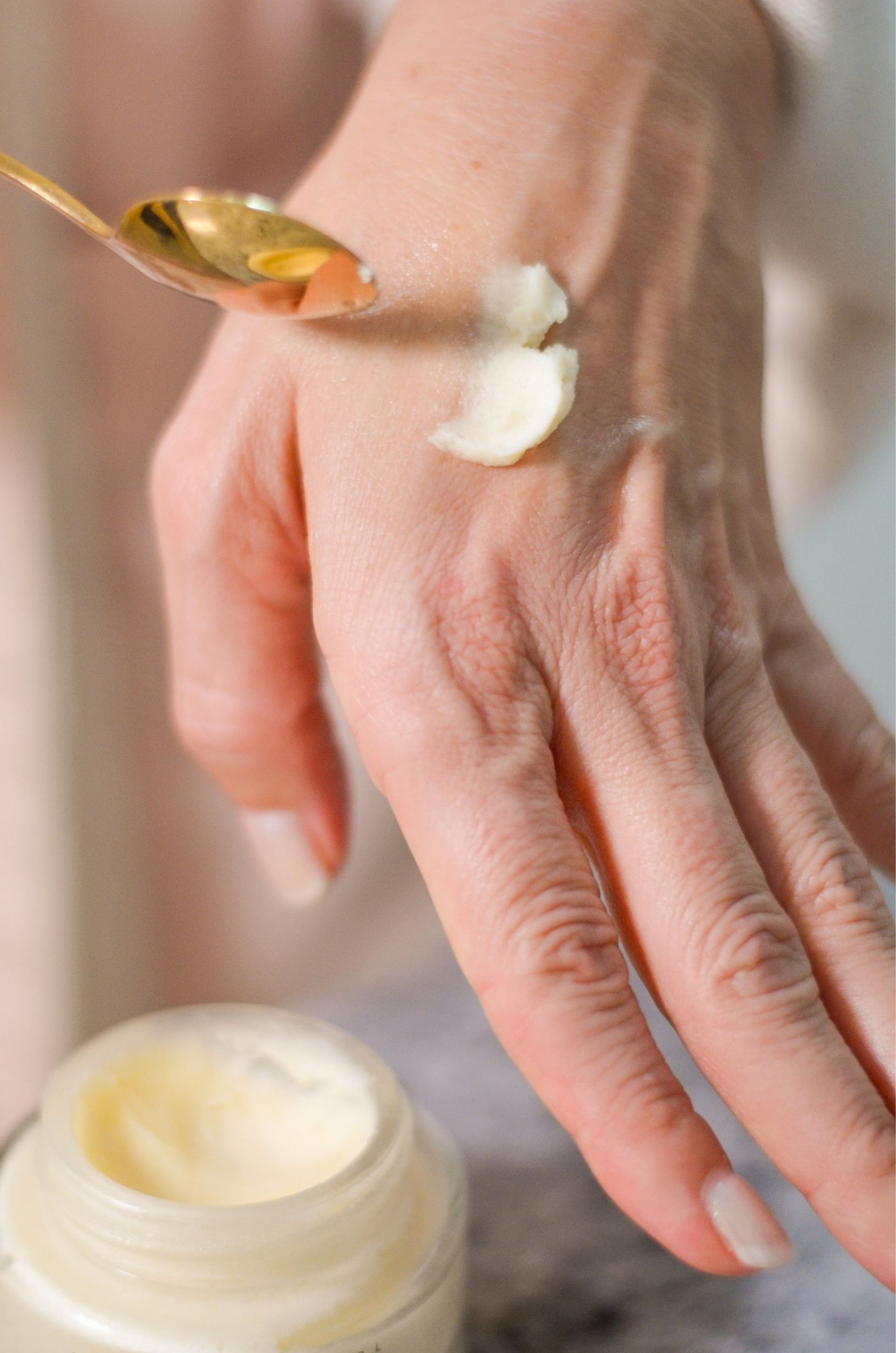 Fresh Face Cream moisturizer texture applied to the back of a hand beside an open jar.
