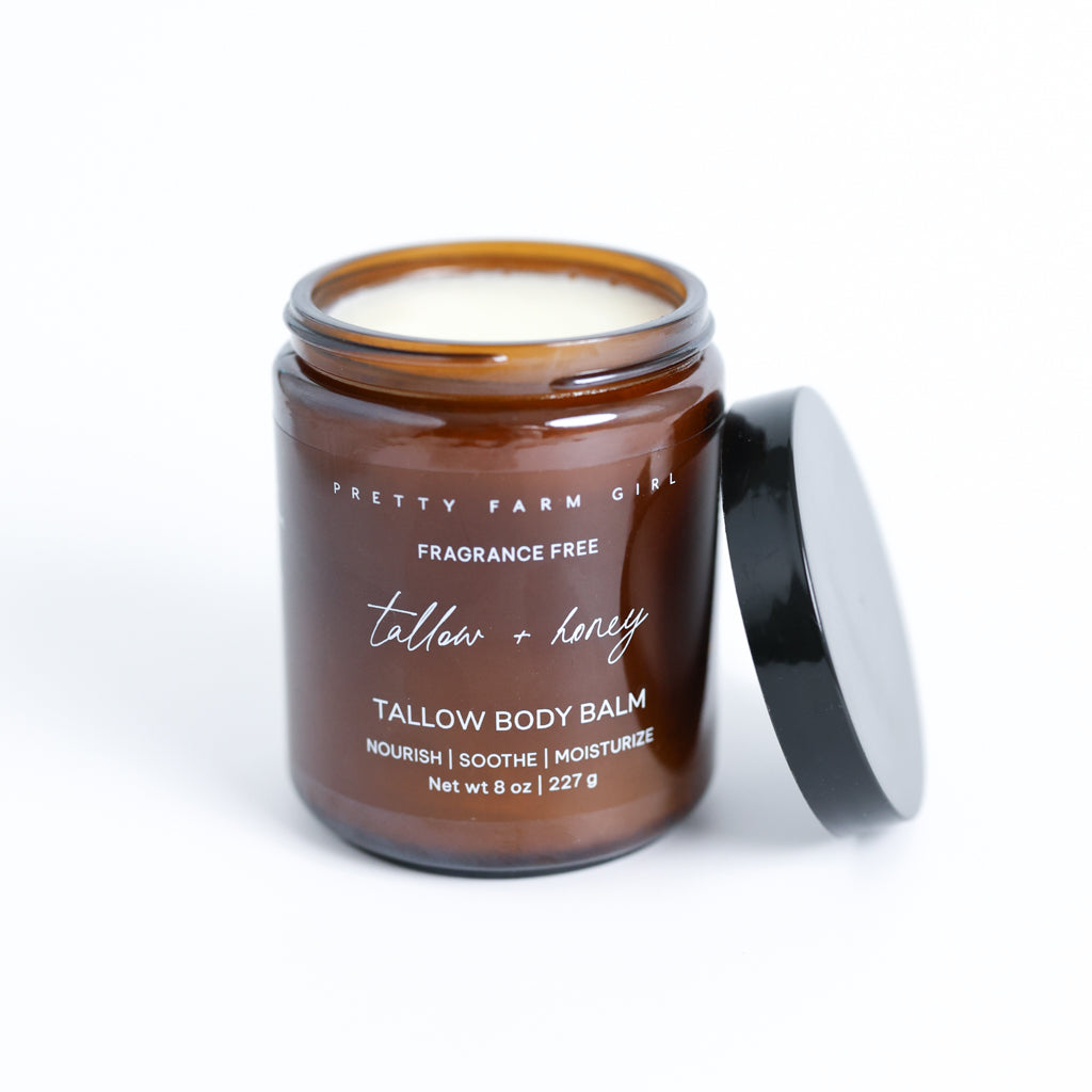Pretty Farm Girl Tallow + Honey Tallow Body Balm jar with black lid on a white background.