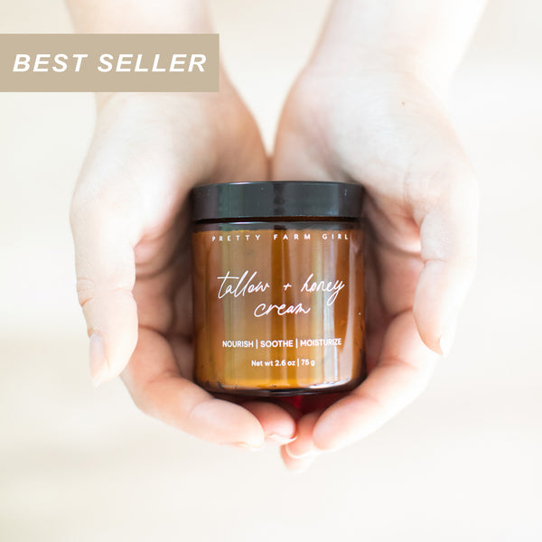 2.6oz glass jar of Pretty Farm Girl's fragrance free Tallow + Honey Cream for sensitive skin, held in hands with 'Best Seller' label above