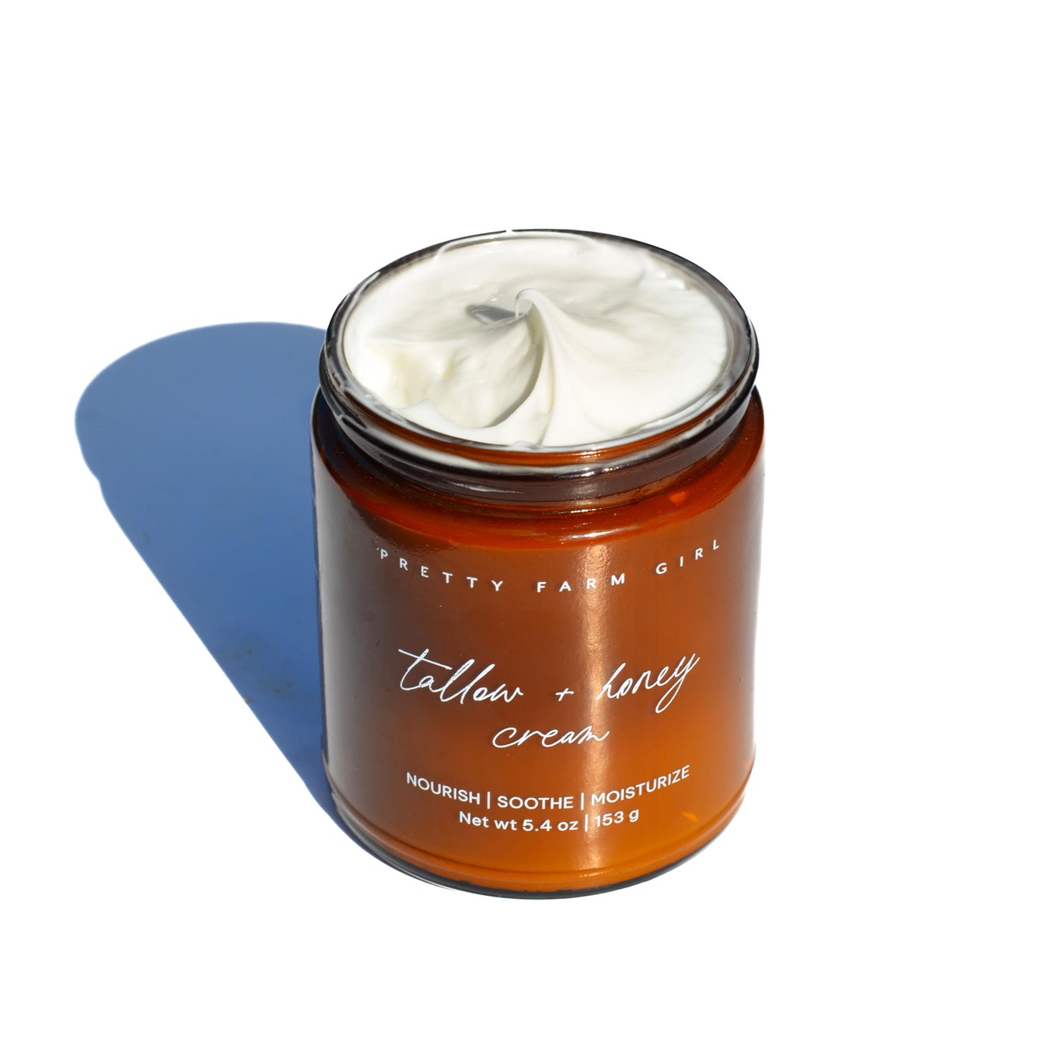 Jar of 'Pretty Farm Girl' tallow + honey cream on a white background