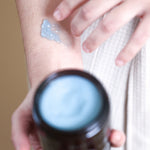 Pretty Farm Girl Tallow + Tansy Tallow Body Balm applied to the arm with the product jar in the foreground.