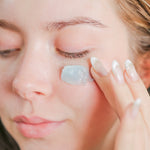 Woman applying Pretty Farm Girl Tallow + Tansy Tallow Body Balm to her cheek.