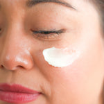 Woman applying Pretty Farm Girl Vanilla Bean Tallow Body Balm to her cheek.