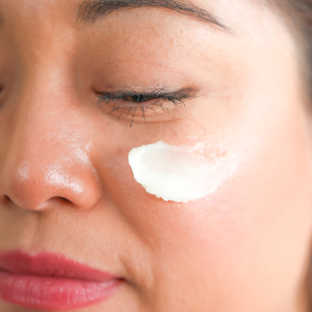 Woman applying Pretty Farm Girl Vanilla Bean Tallow Body Balm to her cheek.