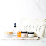 Collection of skincare products on a marble surface with a white background