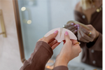 Person holding forehead tape in front of a mirror