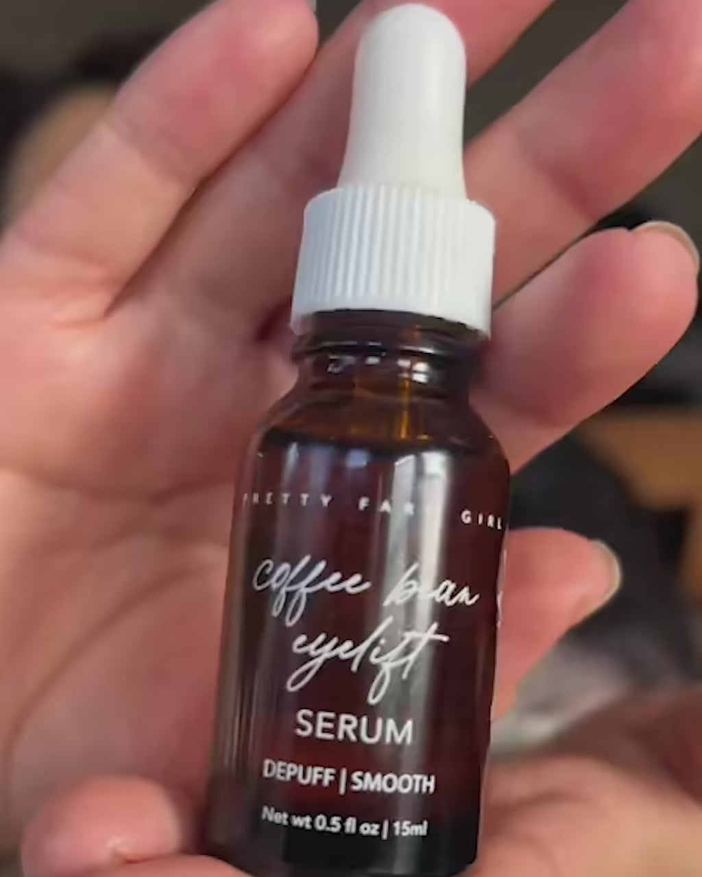 Video showing Coffee Bean Eye Lift Serum bottle held in hand, followed by a woman applying the serum to her face