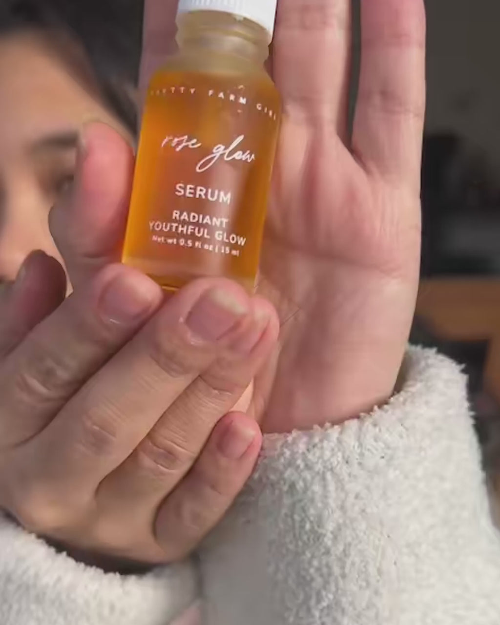 Video of a woman showing Rose Glow Active Botanical Serum bottle and applying the serum to her face