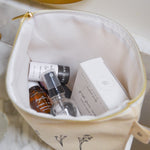 Cosmetic bag with skincare products on a marble surface