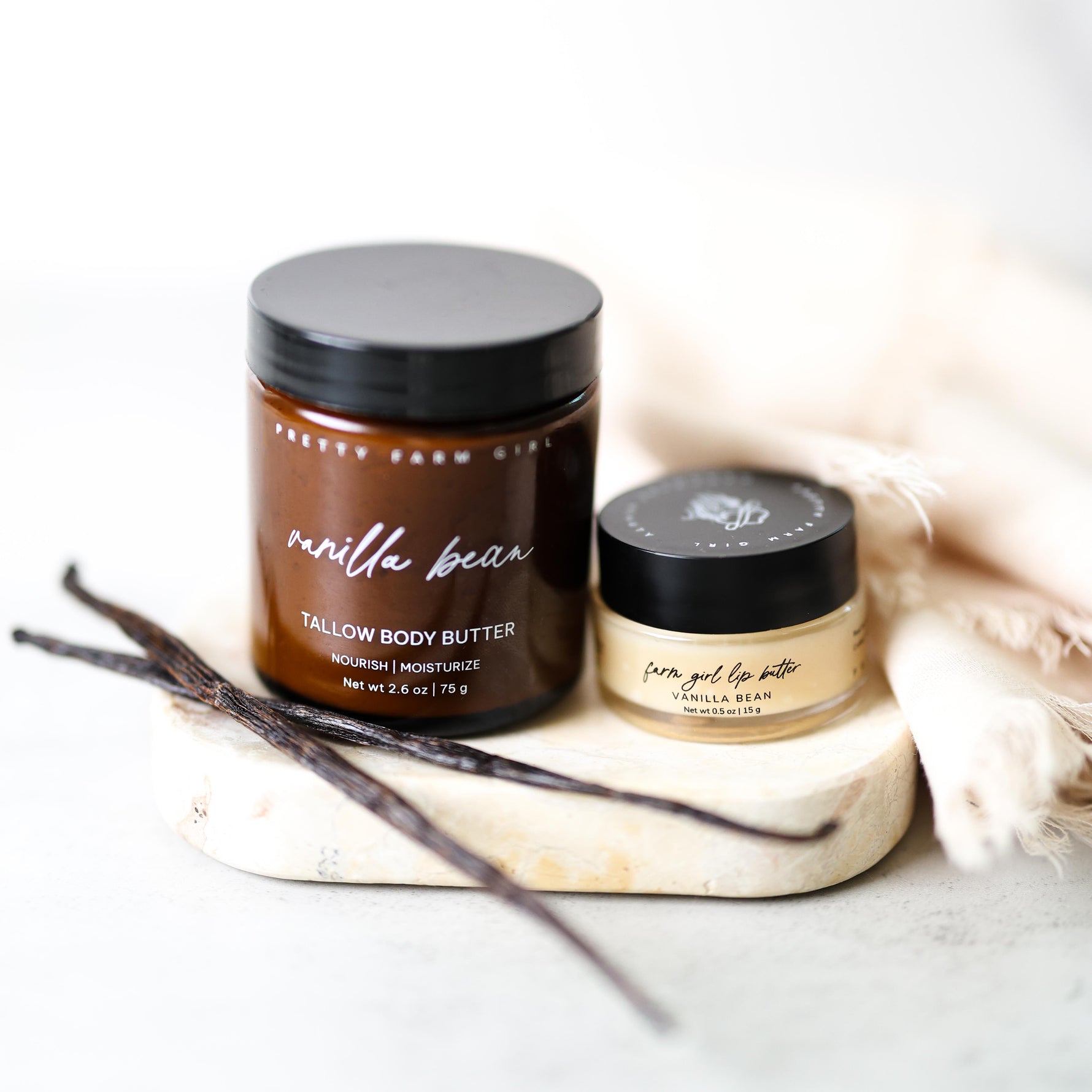 Vanilla bean tallow body butter jars with vanilla beans on a light background