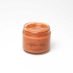 Jar of lip and face polish labeled 'wildflower honey Lip + face polish' on a white background
