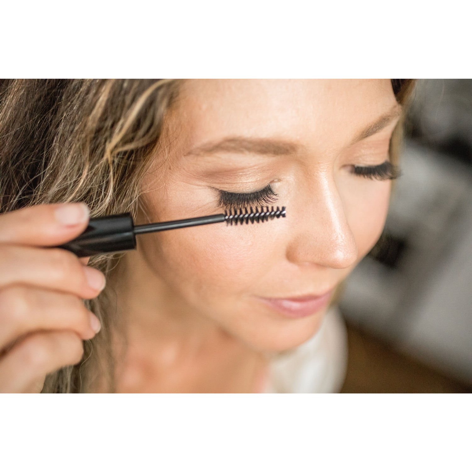 Woman applying Eyelash + Eyebrow Growth Serum to her eyelashes